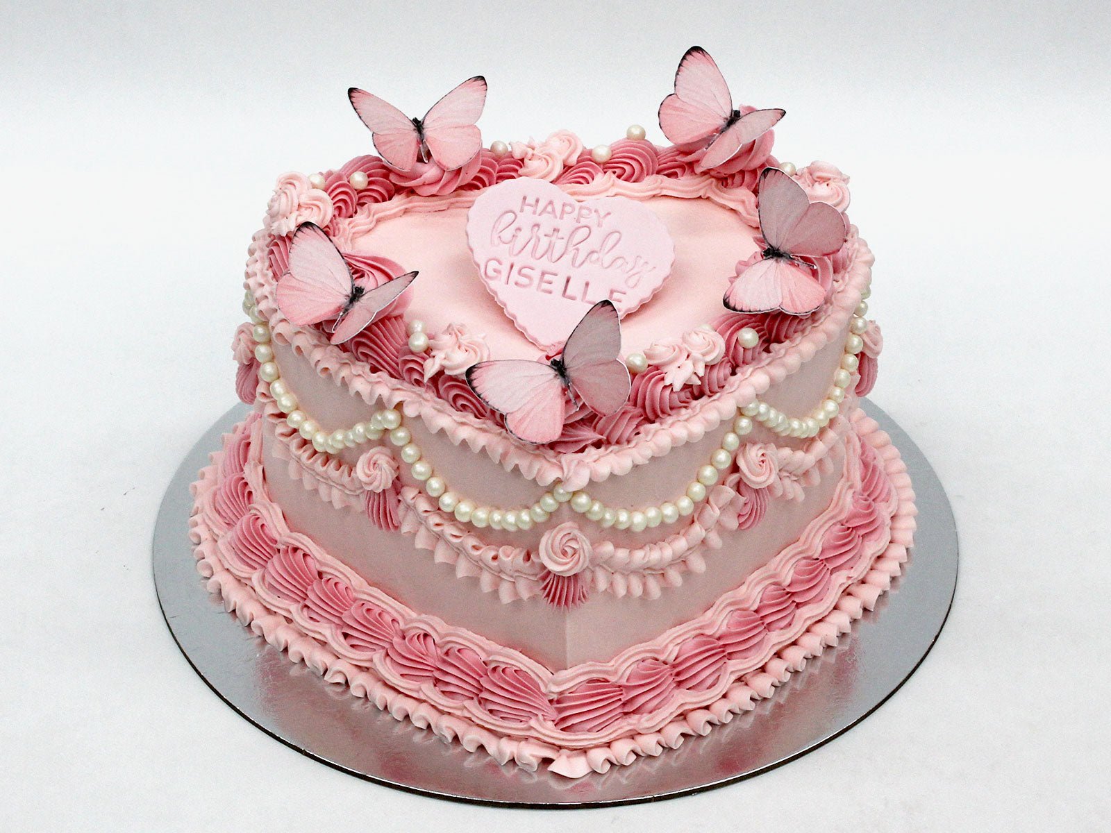 Heart-shaped Vintage Cake with Pink piped buttercream, Pearl Accents & Butterflies.